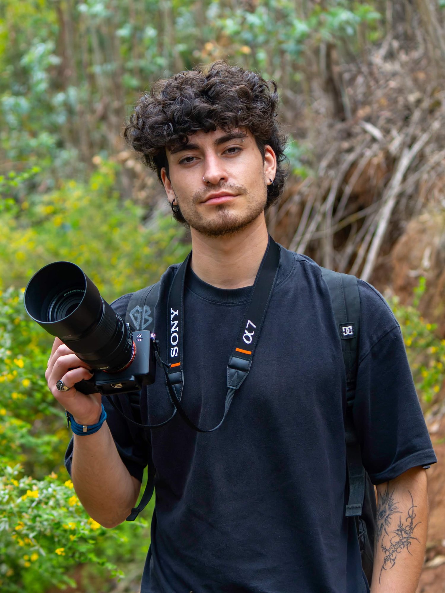Lucas Colipi con su cámara en un sendero rodeado de vegetación